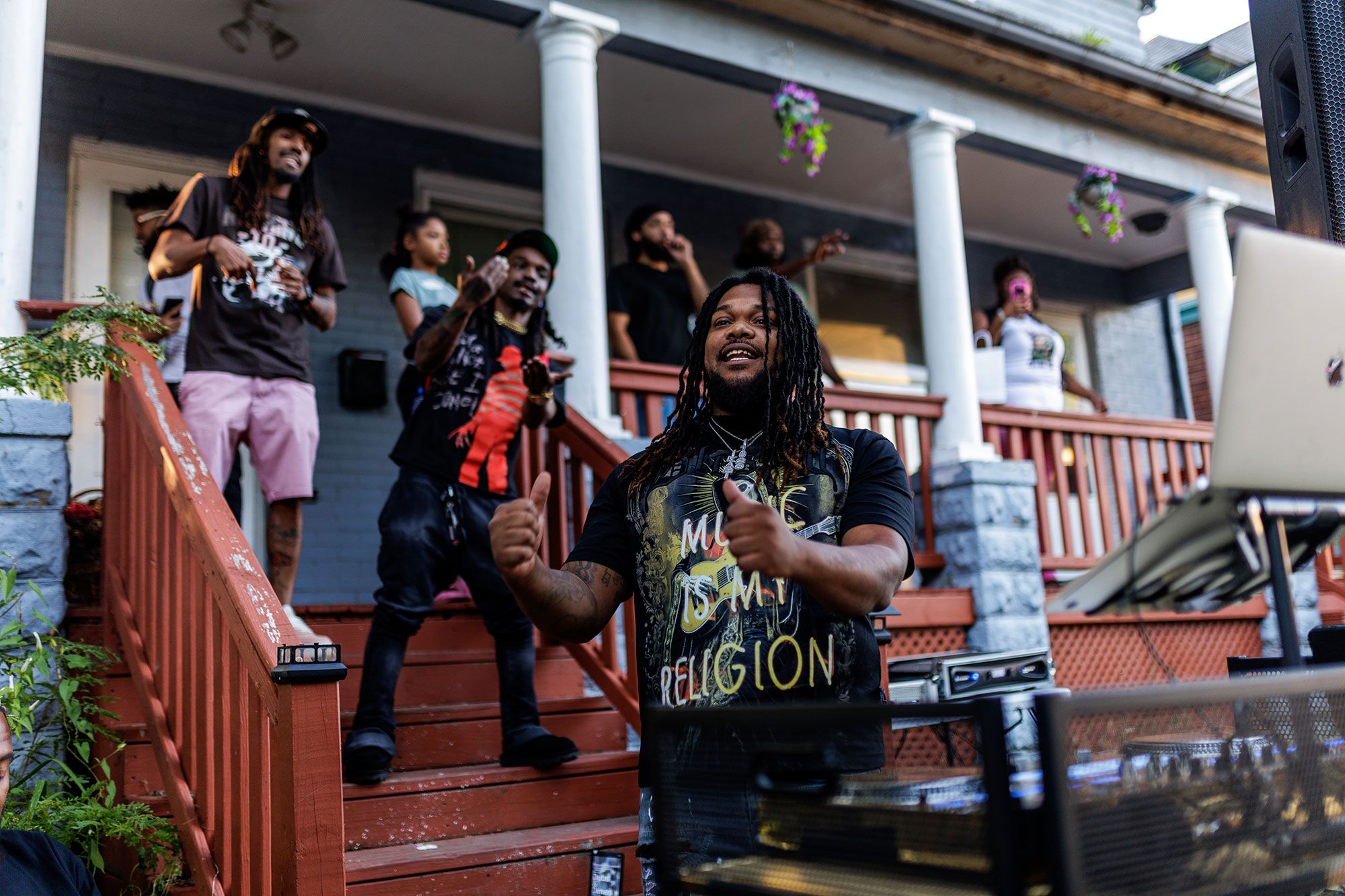 DJ and performers on a red front porch